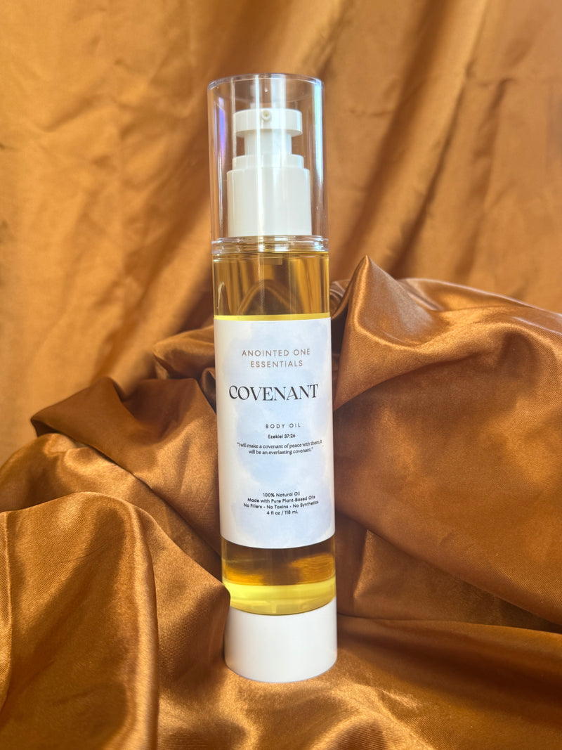 Bottle of Covenant body oil on a gold fabric background